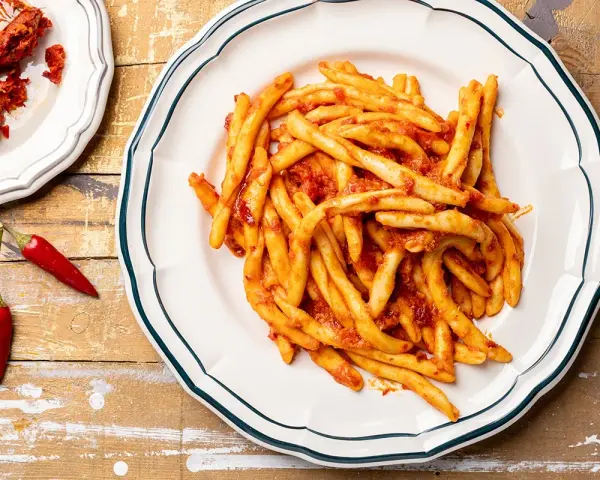 Piatto di pasta con nduja e peperoncini rossi, un classico saporito.