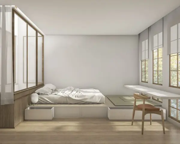 Camera da letto minimalista con letto feng shui, tatami, scrivania a muro e grandi finestre con vista su alberi.
