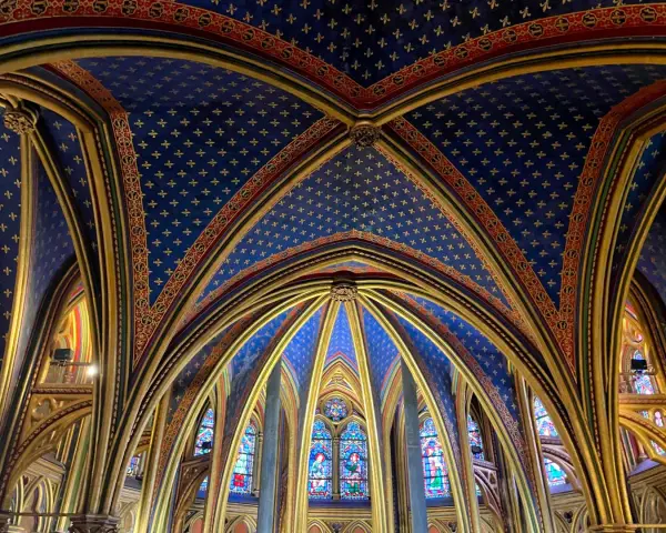 Techo abovedado de la Sainte-Chapelle, con intrincados detalles dorados y un cielo azul estrellado.