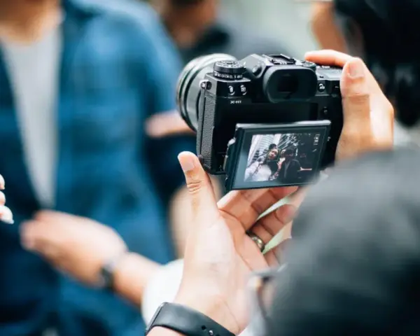 Je découvre la photographie, capturant un selfie de groupe avec un appareil photo moderne.