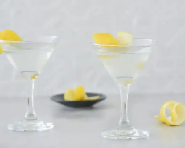 Dwa martini z cytrynową skórką, idealne do przepisu na Dirty Martini.