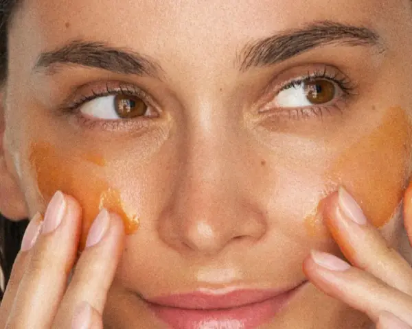 Application d'un masque aloe vera visage. La peau est hydratée et lumineuse, les doigts massent doucement le produit.