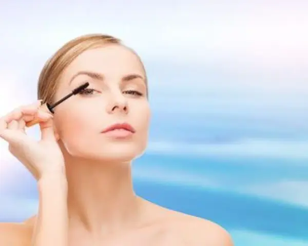 Une femme applique du mascara sur ses cils. Apprendre comment mettre du mascara pour un regard intense.