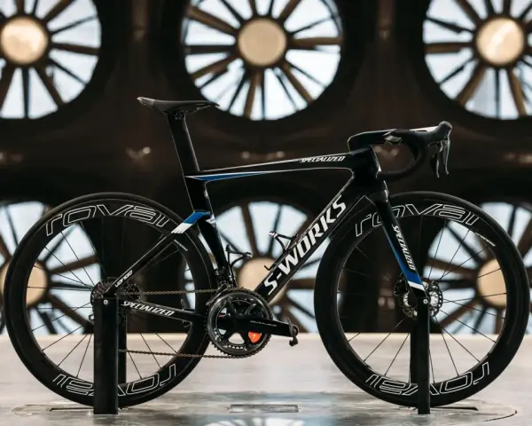 A black S-Works aero bike, designed for speed, is showcased in front of large industrial fans. This is what an aero bike looks like.