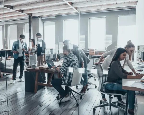 Persone lavorano in un ufficio moderno, un esempio di coworking cos'è: collaborazione e flessibilità in un ambiente dinamico.