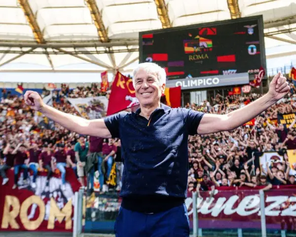 Entrenador sonriente celebra con los aficionados del AS Roma en el Estadio Olímpico.