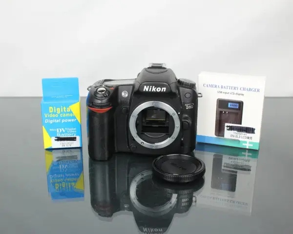 Nikon D80 z akcesoriami: ładowarka i bateria do aparatu cyfrowego.