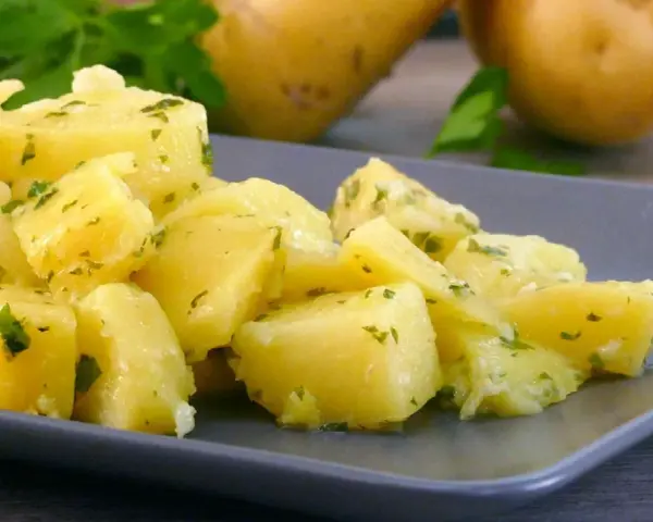 Patatas al microondas cortadas en cubos, aliñadas con perejil y ajo. Un plato sencillo y delicioso.