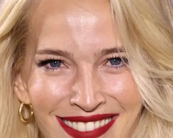 Una mujer sonríe, mostrando cómo cuidar la piel de la cara a los 50 con una piel radiante y maquillaje impecable.