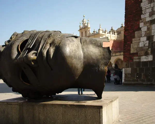 Ogromna, metalowa rzeźba głowy Igora Mitoraja na placu w Krakowie.