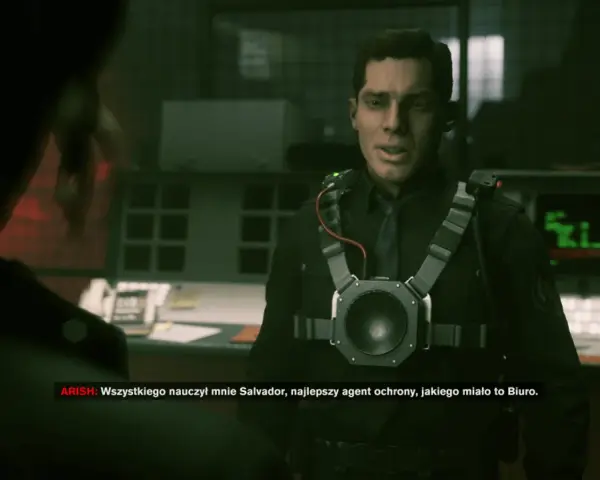 Agent w czarnym mundurze z urządzeniem na piersi, słucha kogoś. W tle monitory. To moment, gdy kontrol czas gry jest kluczowy.