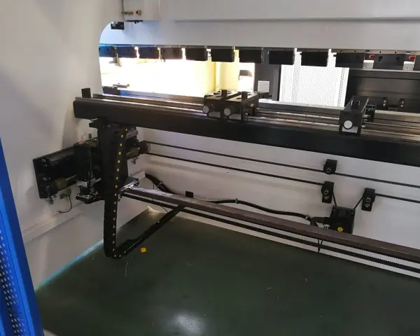 Wnętrze nowoczesnych **pras przemysłowych** z elementami mechanicznymi i prowadnicami.