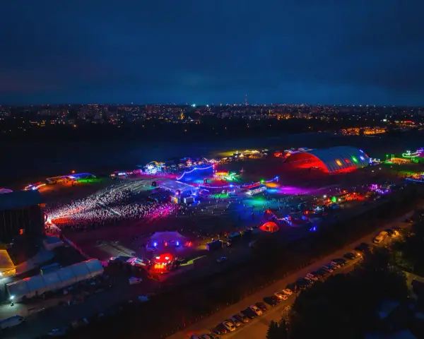 Nocne, kolorowe światła rozświetlają teren festiwalu na powietrzu. Tłumy bawią się pod wielkim, podświetlonym namiotem i na otwartych scenach.