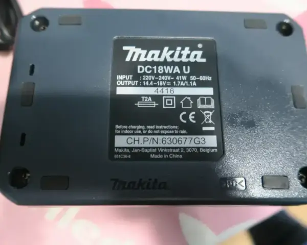 Oznaczenia na akumulatorze Makita DC18WA U: napięcie wejściowe 220-240V, wyjściowe 14.4-18V.
