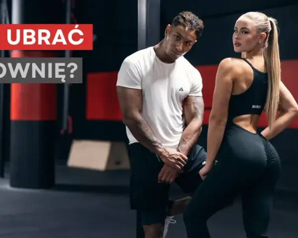 Jaki strój na siłownię? Para w sportowych ubraniach pozuje na tle siłowni.