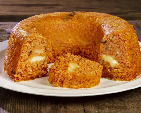 Un invitante timballo di riso, dorato e ripieno di formaggio filante, pronto per essere gustato.