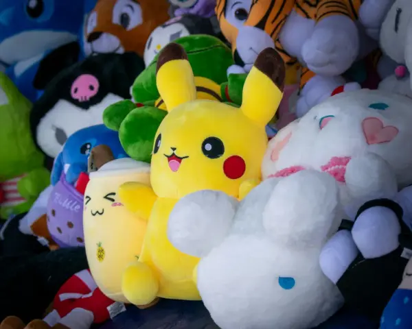 Pluszaki, jak Pikachu i króliczek, czekają na pranie. Kolorowe, miękkie zabawki w różnych kształtach.