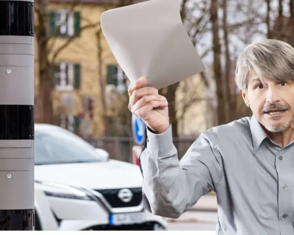 Mann hält Papier hoch, wütend auf Blitzer Arten. Neben ihm ein Messgerät.