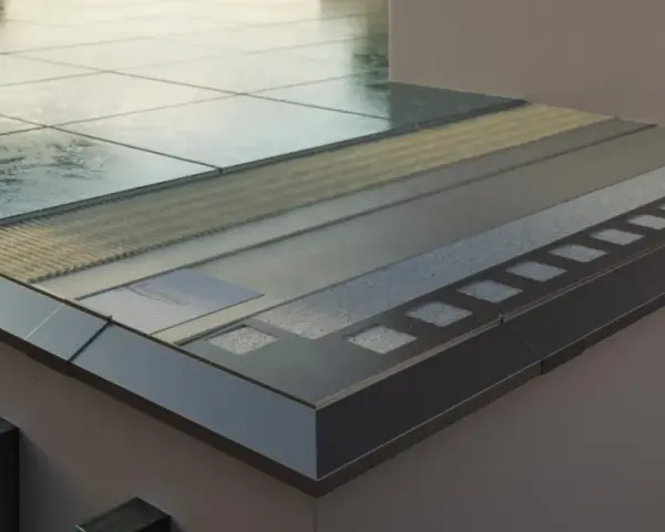 Przekrój nowoczesnej loggii z warstwami izolacji i wykończenia, widoczne płytki i metalowe elementy.