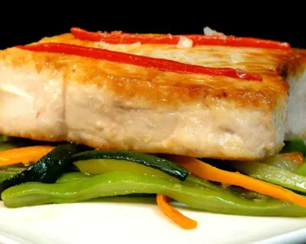 Bonito jugoso con pimientos rojos y verduras salteadas. Una delicia para aprender como cocinar el bonito para que quede jugoso.