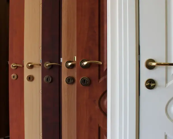 Variedad de tipos de puertas de madera y blancas, con diferentes acabados y manijas doradas.