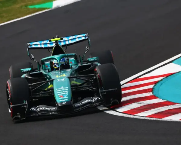 El coche Aston Martin F1, con el número 14, acelera en una curva.