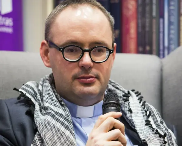 Ksiądz Kaczkowski, w okularach i z szalem, dzieli się cytatami o życiu.