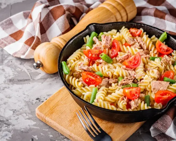 Makaron z tuńczykiem, pomidorkami i fasolką szparagową w patelni.