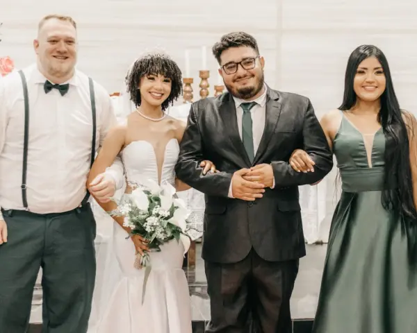 Sposi con due testimoni, un uomo e una donna, sorridono felici. Il rito civile quanti testimoni? Due sono sufficienti per suggellare l'amore.