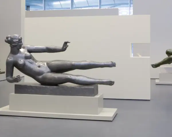 Exposition d'œuvres d'art de Aristide Maillol : sculptures de femmes nues en bronze et en métal, dans un musée.