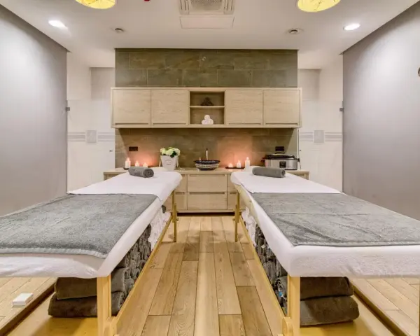 Dwie leżanki do masażu, świece i kwiaty tworzą atmosferę relaksu. Idealne miejsce na 2-dniowy pobyt w spa dla dwojga.