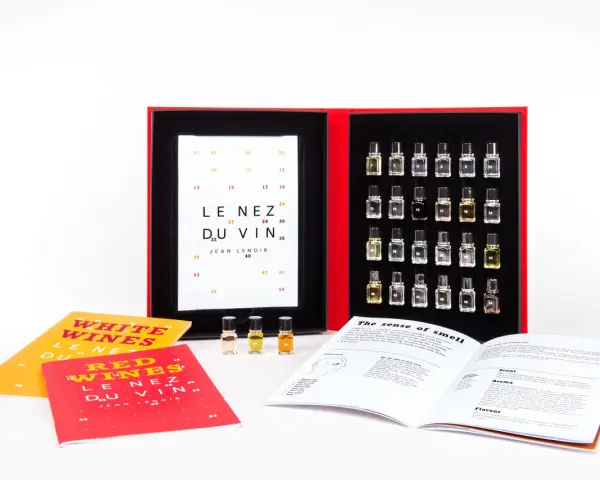 Kit de degustación "Le Nez du Vin" con pequeños frascos de aromas, libros y una tabla de cata.