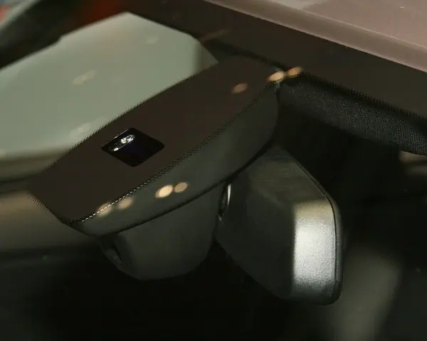 Nahaufnahme eines Regensensors im Auto, der die Windschutzscheibe überwacht, um bei Regen die Scheibenwischer zu aktivieren.