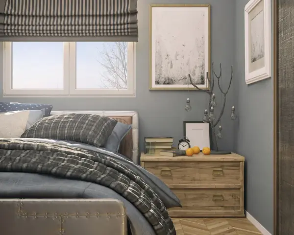 Ideas para decorar una habitación: cama con textiles grises, mesita de noche de madera con adornos y cuadros en la pared.
