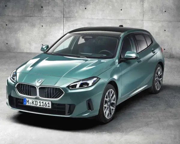 Nowy, zielony bmw hatchback z czarnym dachem, zaparkowany na betonowym podłożu.