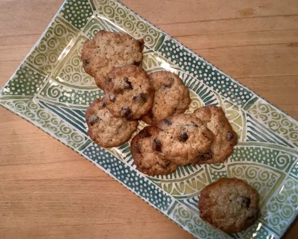 Leckere sauerteig cookies mit Schokoladenstückchen auf einer grünen, gemusterten Platte.