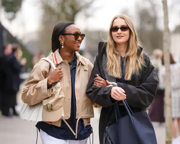 Due amiche con outfit alla moda, un esempio di must significato nella moda.