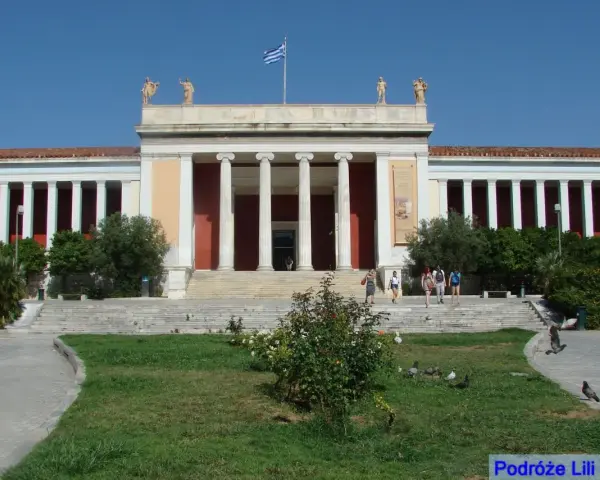 Narodowe Muzeum Archeologiczne w Atenach, z grecką flagą na dachu, zaprasza zwiedzających.