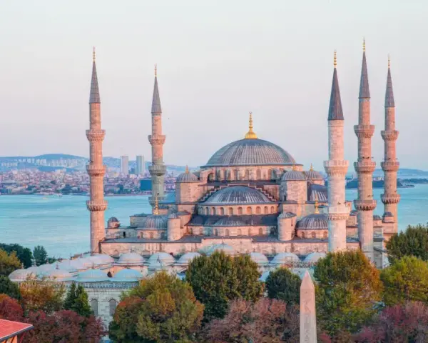 Błękitny Meczet w Stambule, z minaretami górującymi nad miastem i morzem. Czy Istambuł jest bezpieczny? Turyści spacerują pośród pięknej architektury.