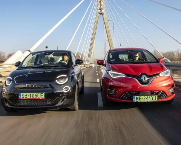 Czarny fiat elektryczny i czerwony samochód jadą po moście.