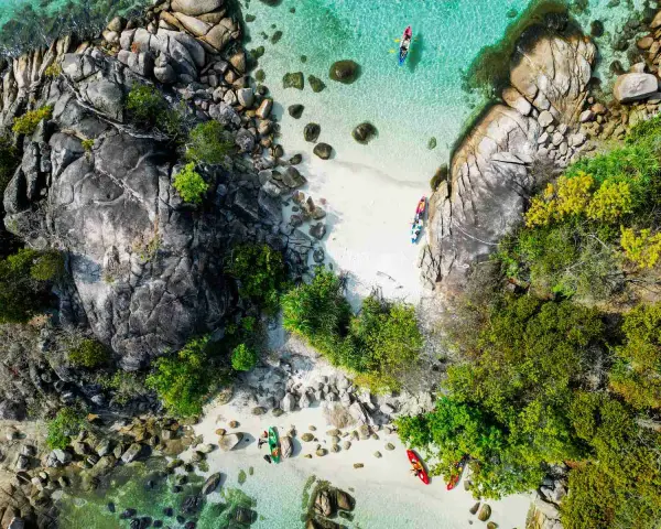 Wybierasz się do Tajlandii? Spakuj kajak i odkrywaj rajskie plaże z krystalicznie czystą wodą, jak ci ludzie na zdjęciu.