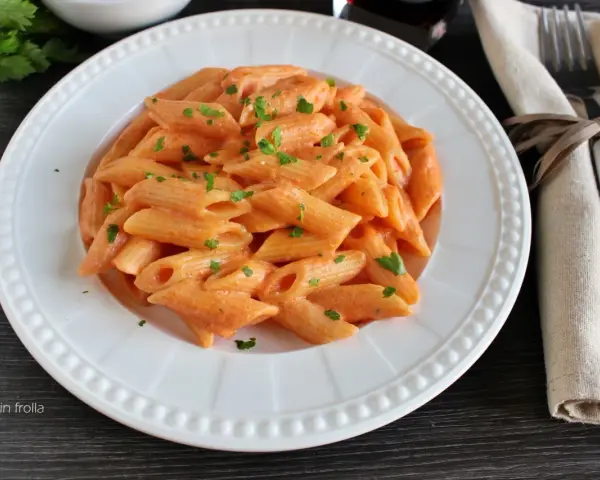 Penne cremose con un sugo rosa, arricchito dal gusto del philadelphia, guarnite con prezzemolo fresco.