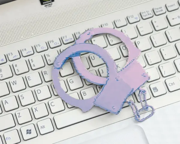 Różowe kajdanki na klawiaturze laptopa symbolizują problemy ze sklepem z aplikacjami.