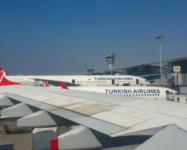 Samoloty Turkish Airlines na płycie lotniska. W tle terminal i wieża kontroli lotów. Czekam na mój bagaż.