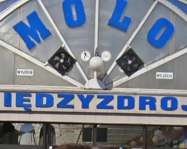 Napis "MOLO" i "MIĘDZYDROJE" na budynku, który może być częścią Alei Gwiazd w Międzyzdrojach.