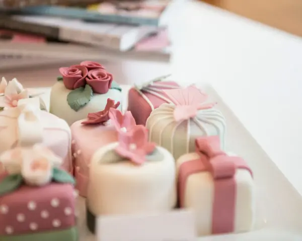 Urocze mini deserki, idealne na tort panieński. Różowe różyczki, kwiaty i kokardki zdobią słodkości.