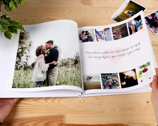 Otwarta fotoksiążka z romantycznymi zdjęciami pary i cytatem o miłości. Idealne miejsce na ciekawe teksty do fotoksiążki, które podkreślą Wasze wspomnienia.