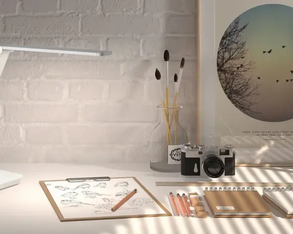 Lámpara LED moderna sobre un escritorio con bocetos de pájaros, cámara antigua y un póster inspirador. La luz es ideal para estudiar.