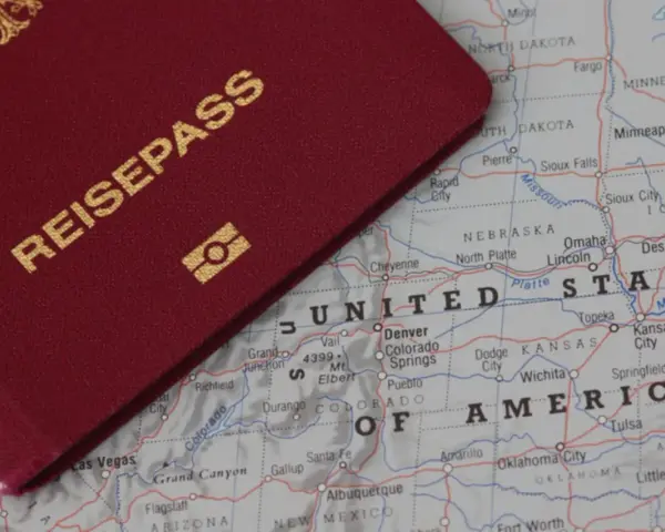 Ein roter Reisepass liegt auf einer Karte der USA. Perfekt für deinen **Gap Year USA** Traum!