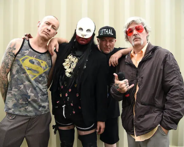 Członkowie Limp Bizkit, gotowi by break stuff, pozują do zdjęcia. Jeden w koszulce z Supermanem, drugi w masce, trzeci w czapce "Lethal", a czwarty z mikrofonem.